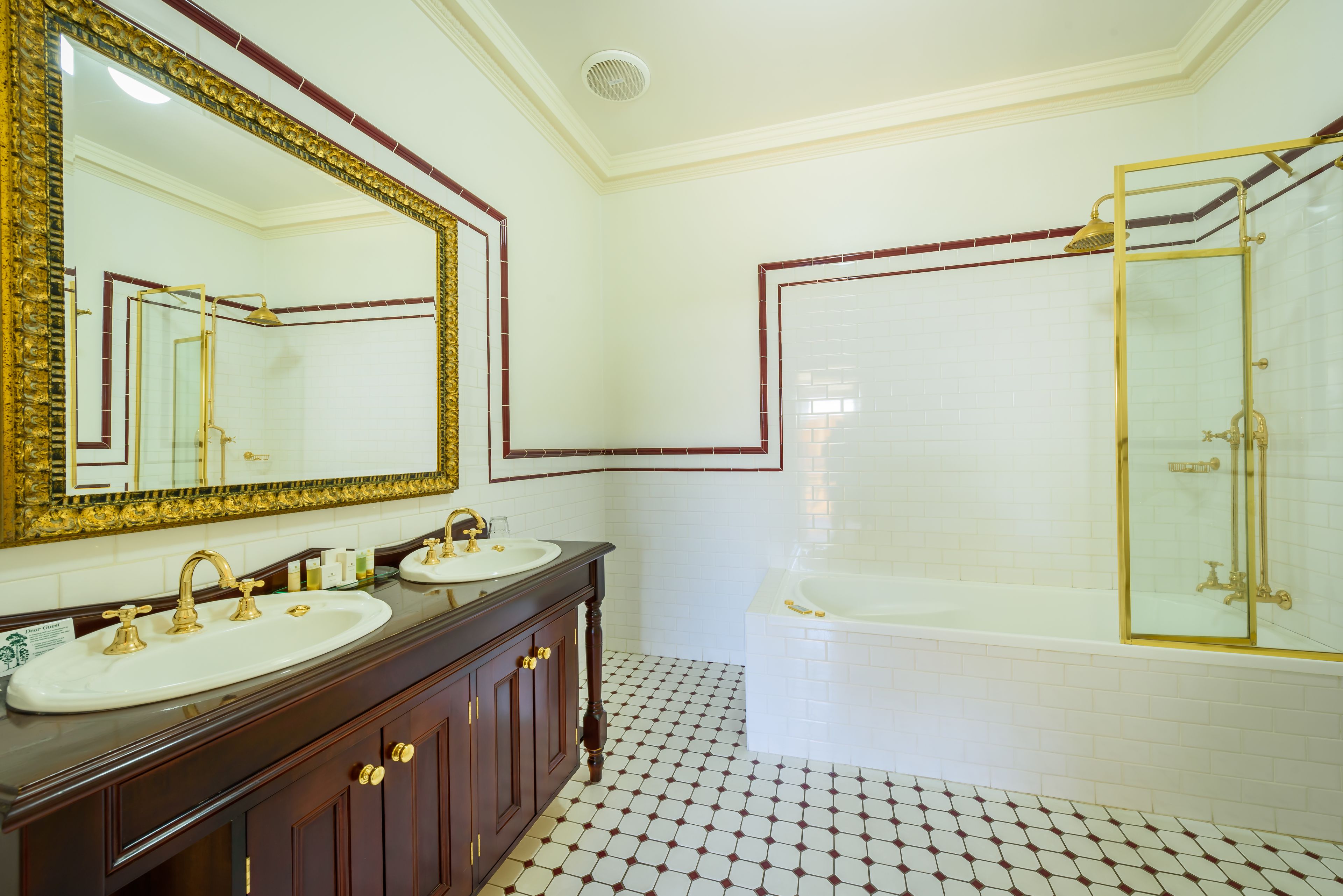 A bathroom with two sinks, a large mirror, and a bathtub.
