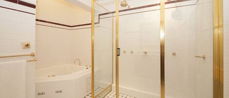 Une salle de bain avec une douche à parois de verre, une baignoire et des toilettes.