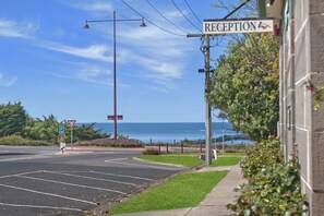 A reception area with a view of the ocean, a parking lot, and a pedestrian crossing sign.