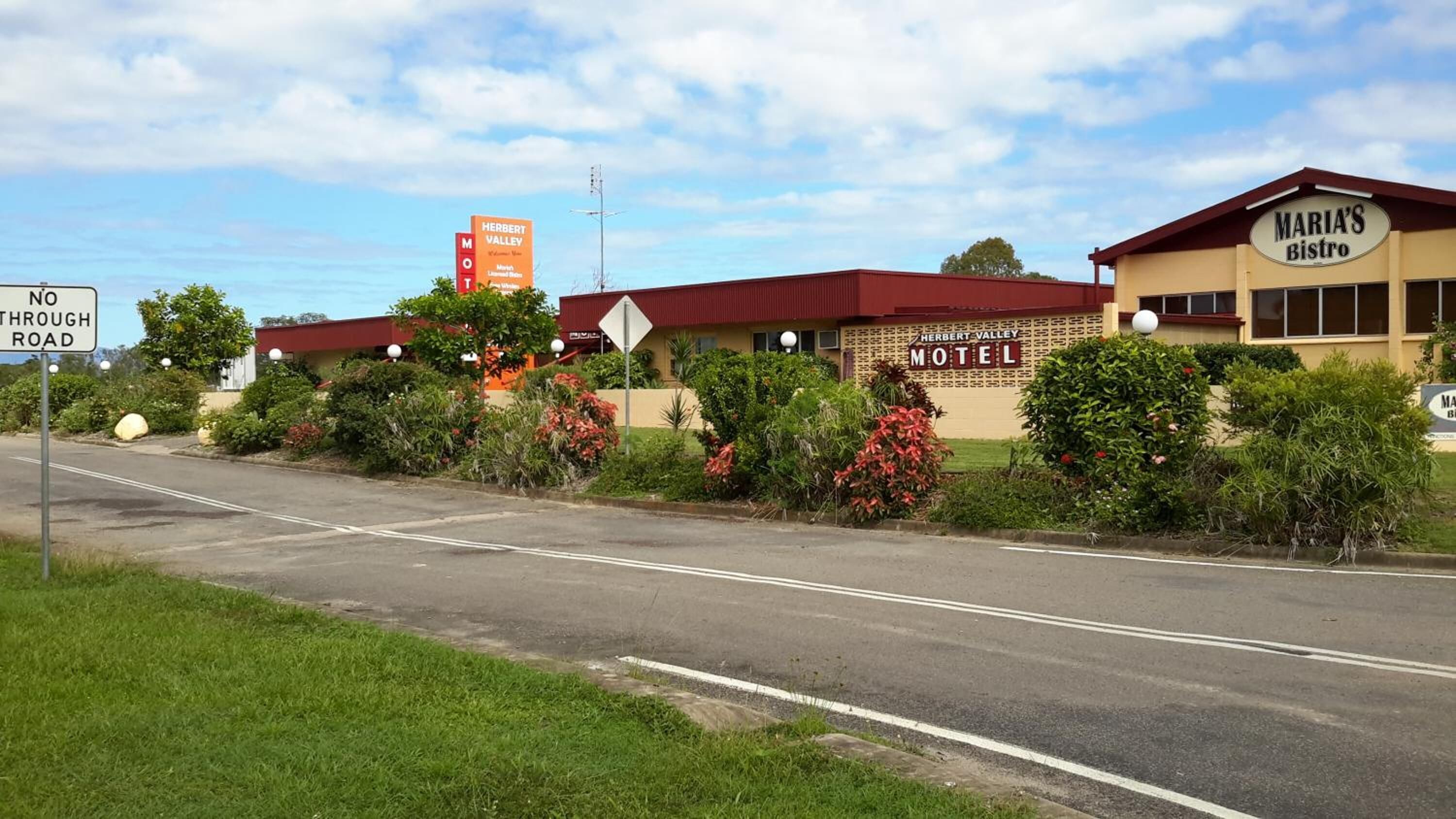 Een motel met een rood dak en een bord waarop staat: Herbert Valley Motel.