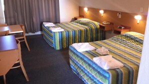Una habitación de hotel con dos camas, un escritorio y una silla.