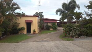 Un edificio residencial con techo rojo, puerta principal y una entrada con portón.