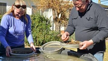 Two people near a water filtration system outdoors.