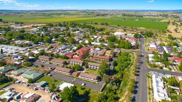 An aerial view of a residential area with houses, roads, and green fields.