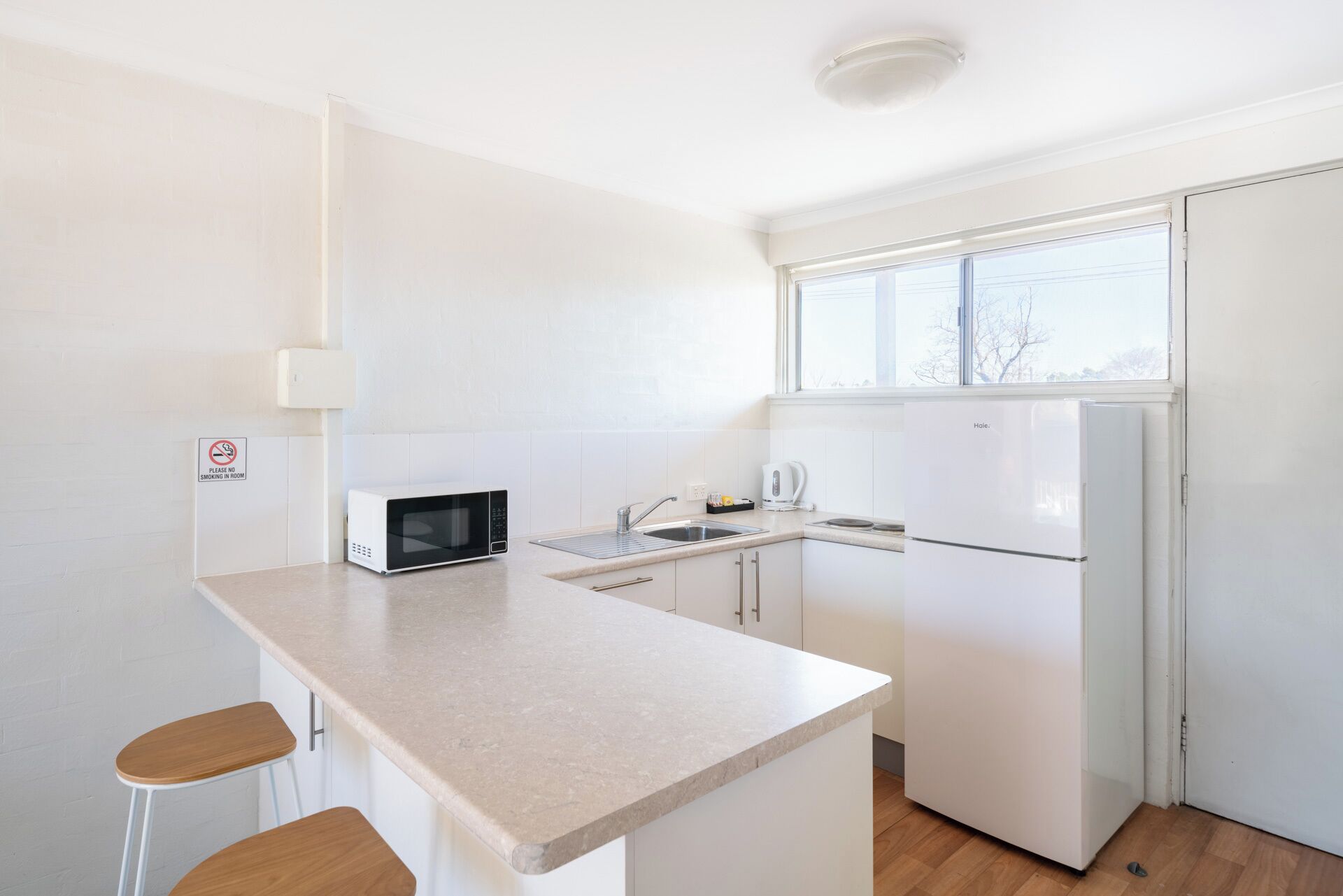 A compact kitchen with a microwave, sink, and refrigerator.