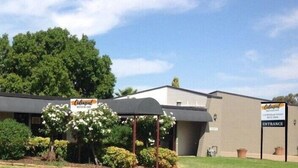 A building with a sign that reads "Colonial" and another sign indicating an entrance.