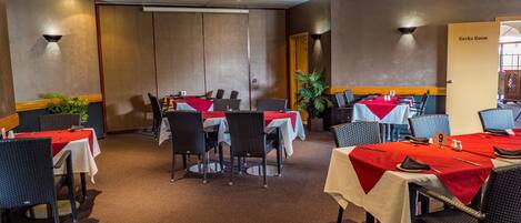 A conference room with tables set for meetings, equipped with chairs and a projector.