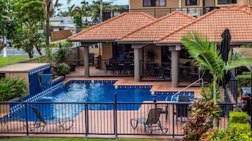 Alberca al aire libre, sombrillas en la alberca y camastros