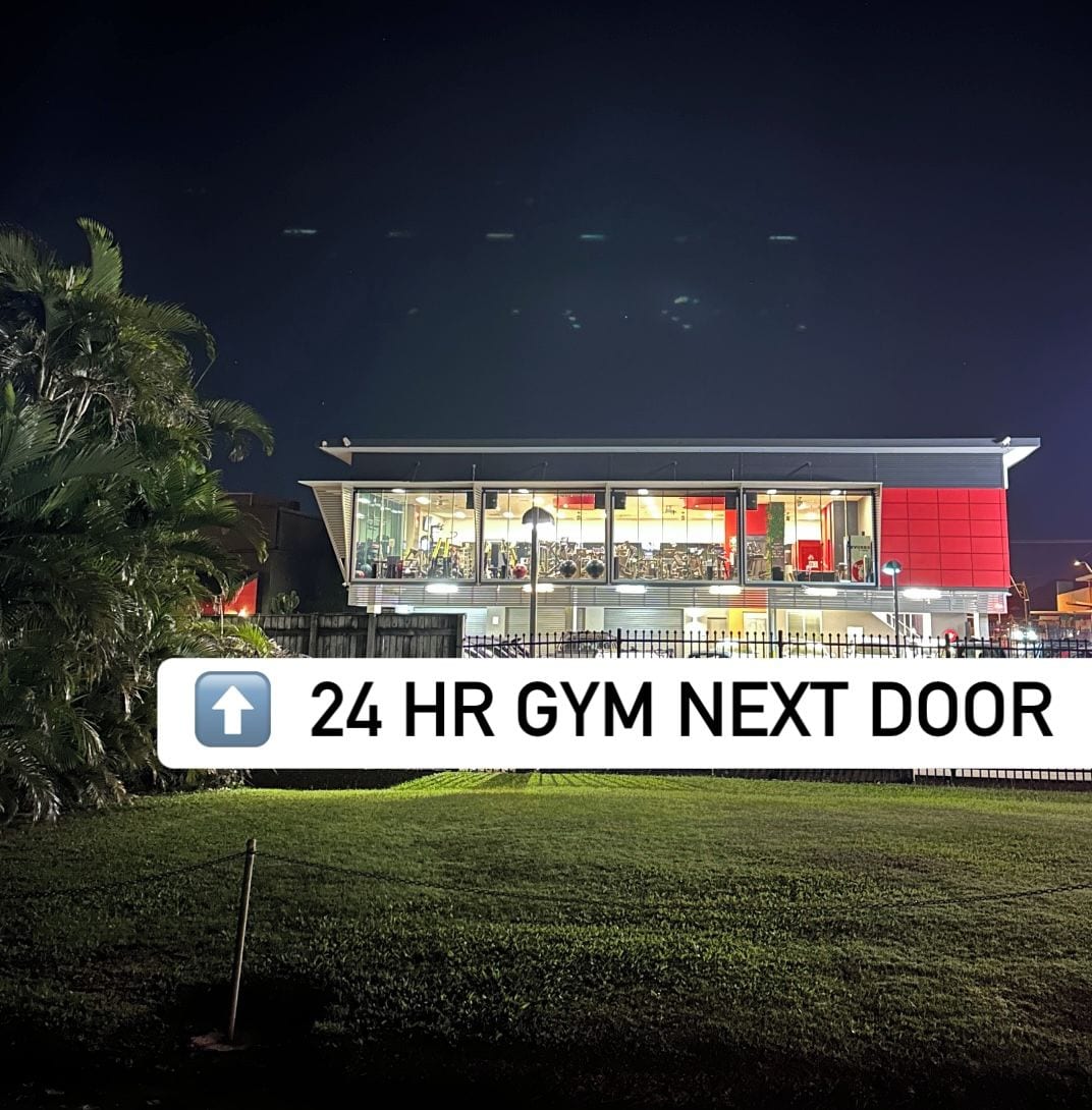 Une salle de sport ouverte 24 heures sur 24, avec un panneau indiquant l’entrée située à la porte suivante.