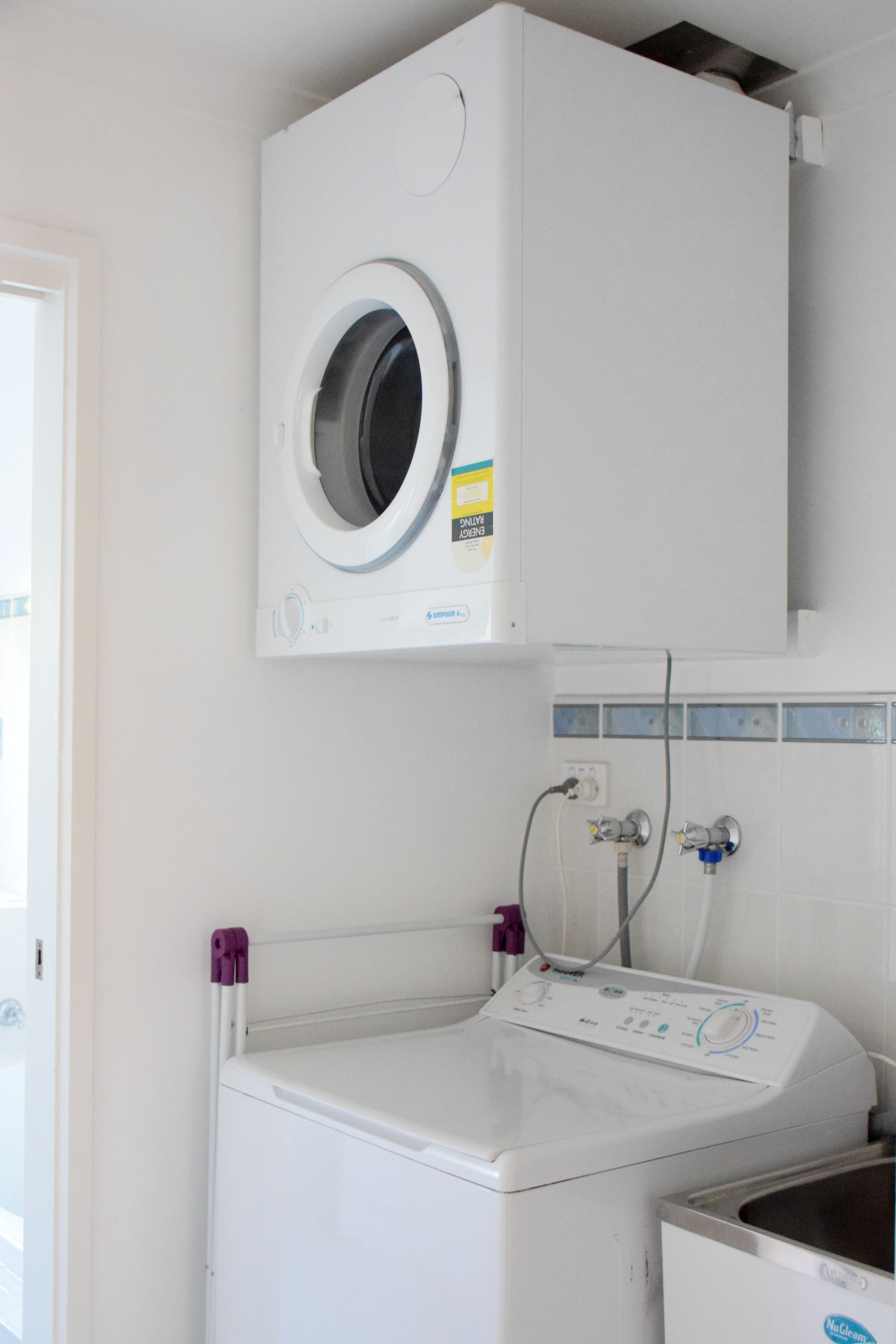 A laundry area with a front-loading washing machine and a top-loading dryer.