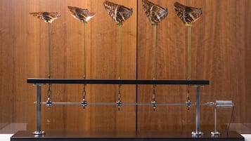A display of butterfly-shaped objects mounted on a metal stand with a wooden background.