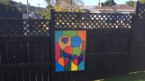 Una reja de metal negro con una llamativa obra de arte abstracta.