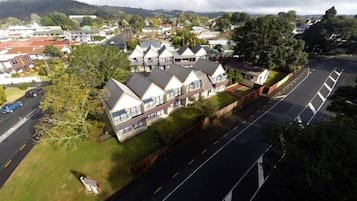 A residential area with houses, a road, and a hill in the background.