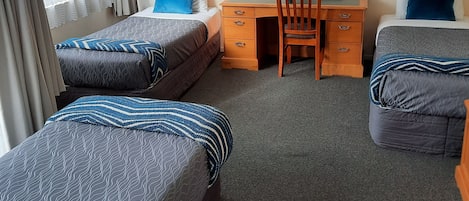 Una habitación de hotel con dos camas individuales, un escritorio y una silla.