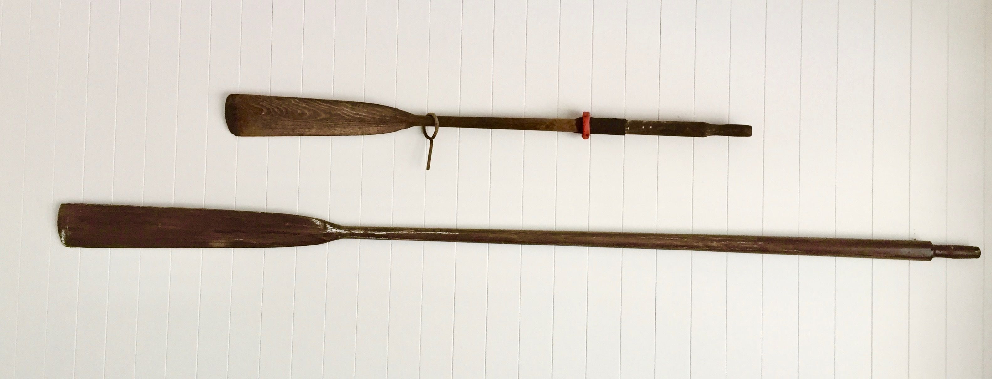 Two wooden paddles on a lined surface.
