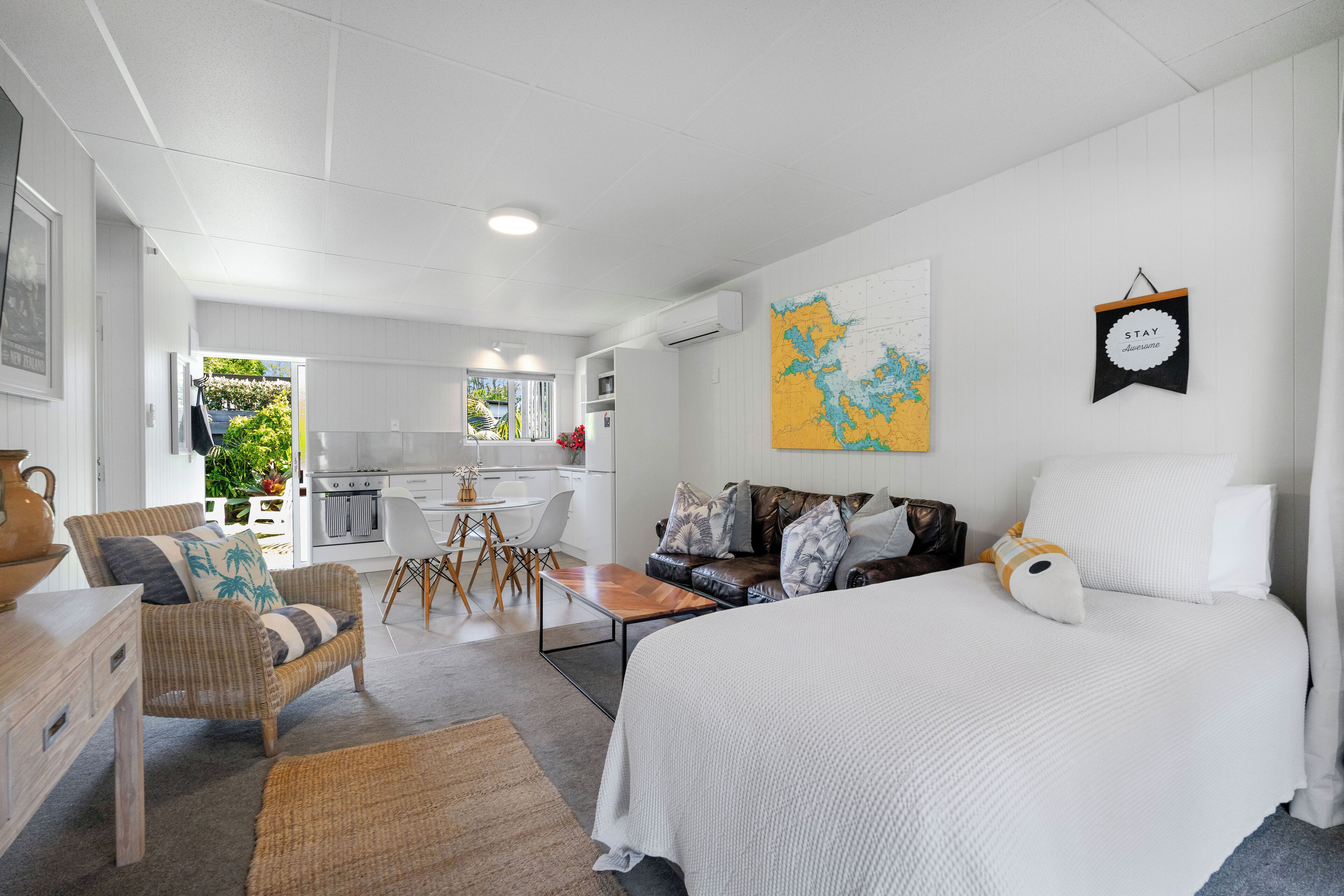 Una habitación moderna y bien iluminada con una cama grande, un sofá y un comedor.
