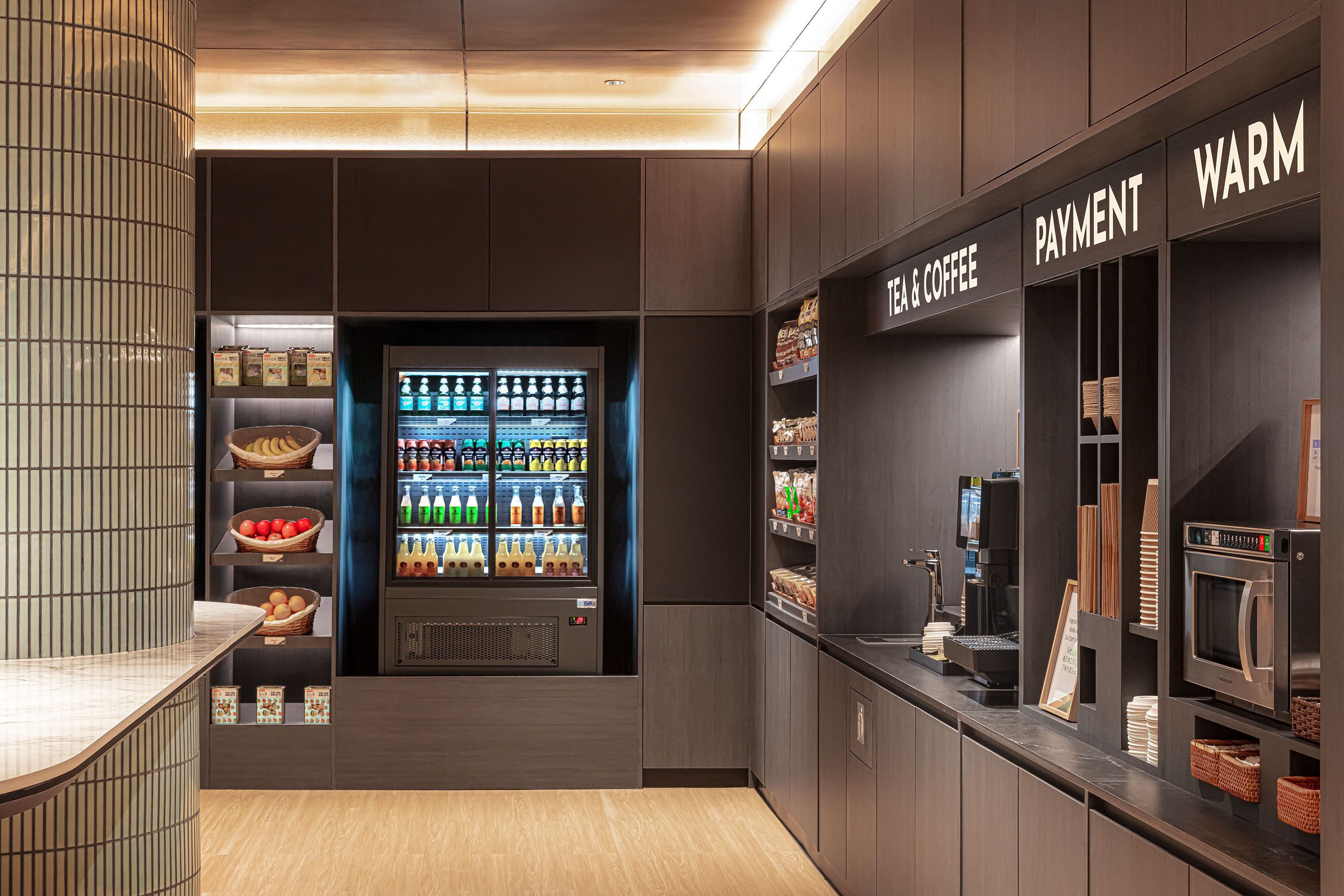 Una cafetería moderna con una máquina expendedora de bebidas, una caja de pago y una estación de café.
