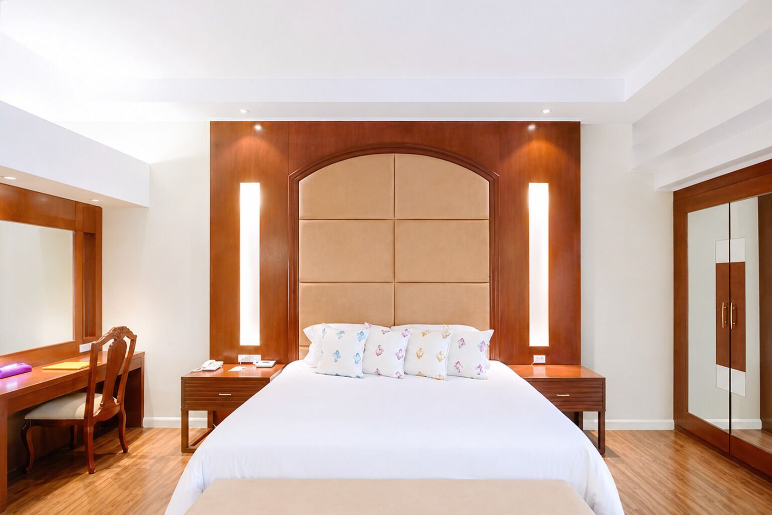 Een hotelkamer met een groot bed, een bureau, een stoel en een kledingkast.