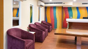 A room with purple chairs, a wooden table, and a colorful wall.