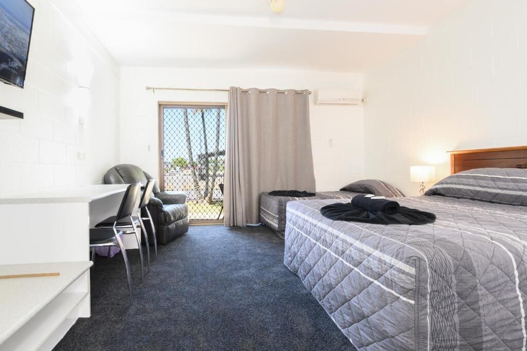 Een hotelkamer met een bed, een bureau, een stoel en een televisie.