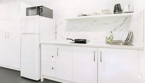 Geladeira grande, micro-ondas, cooktop, cafeteira/chaleira