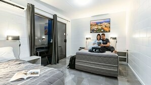 Una habitación de hotel moderna con cama, escritorio y zona de estar.