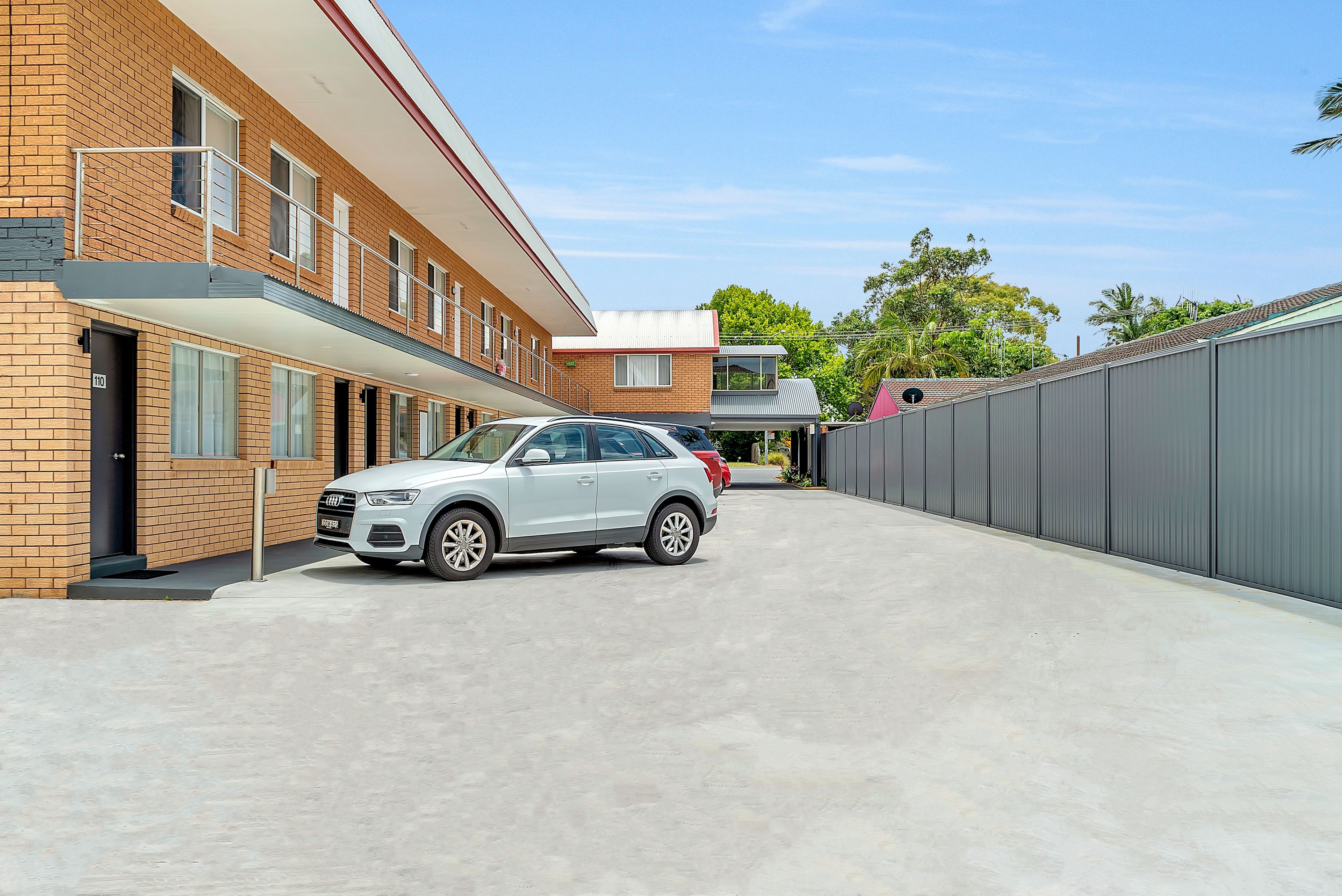 Un bâtiment moderne avec une voiture blanche garée devant.