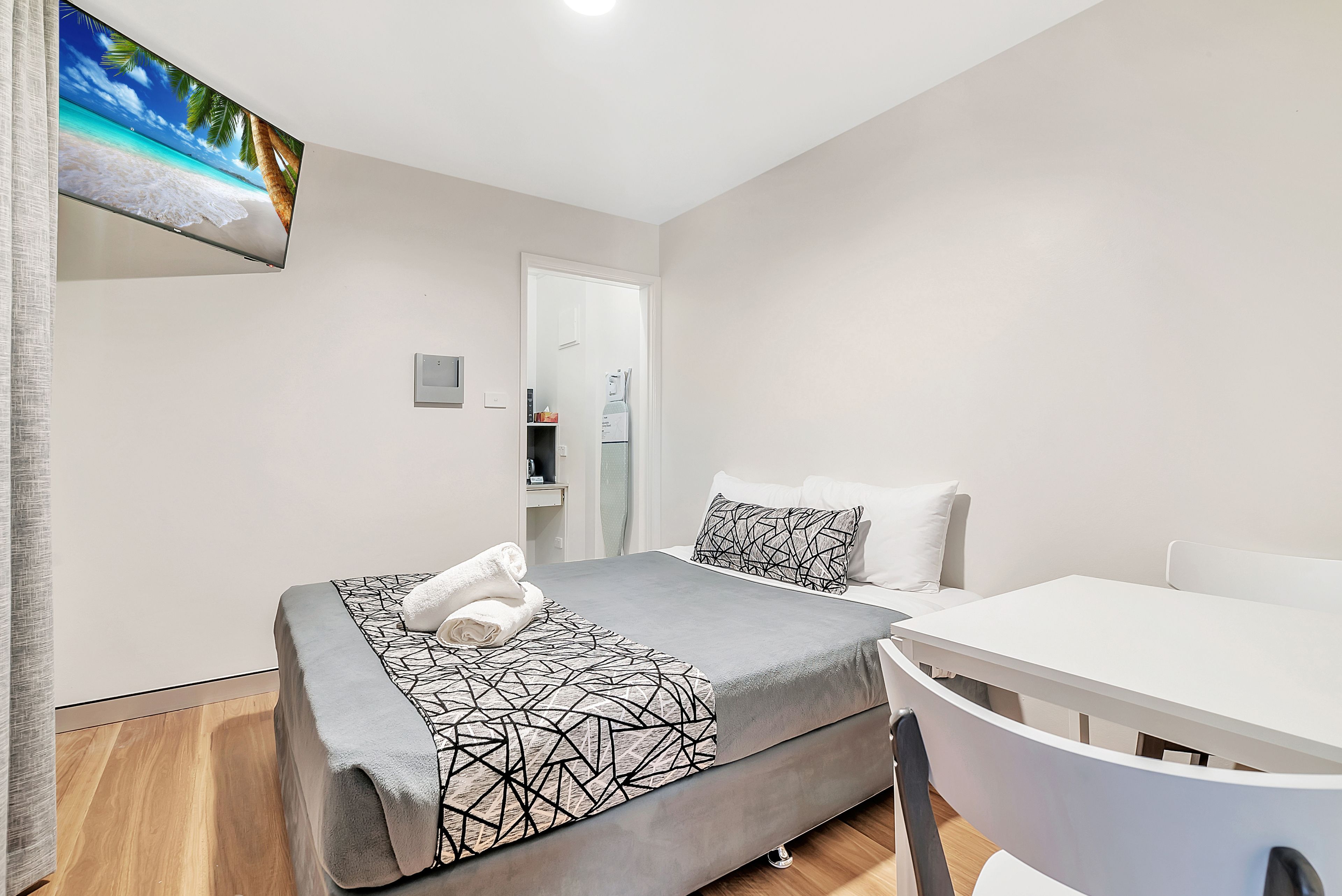 Ein modernes Hotelzimmer mit einem Bett, einem Schreibtisch und einem Stuhl.