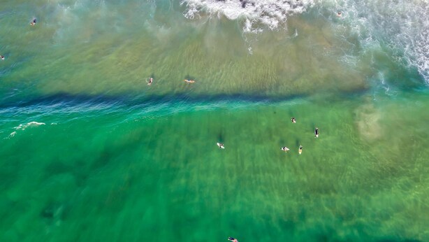 An aerial view of a coastal area with clear turquoise waters and a sandy beach. - Surf Beach Motel Port (Port Macquarie)