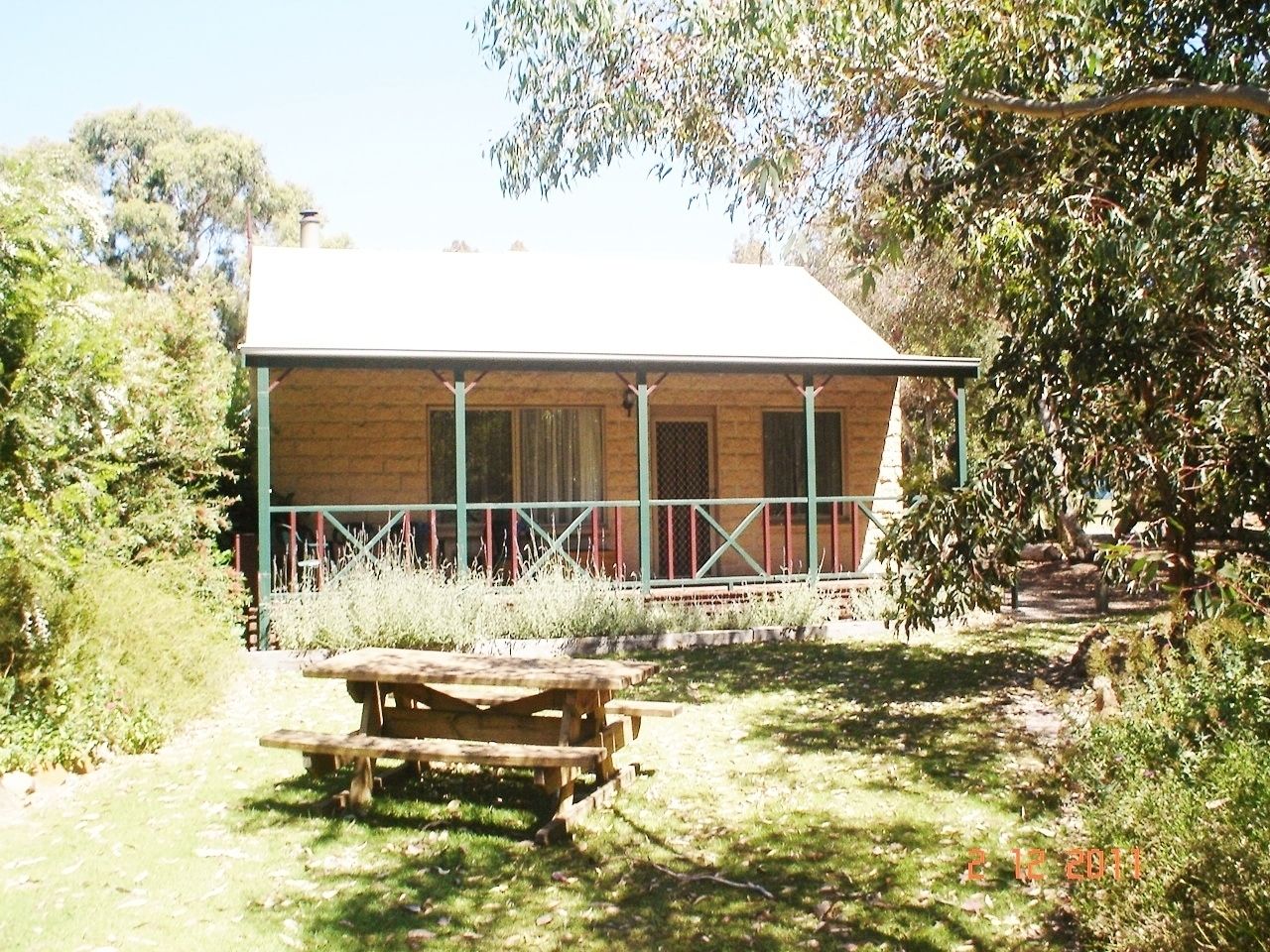 A rustic building with a covered porch and a picnic table in front.