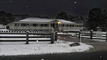 A large, illuminated building with a snow-covered landscape.