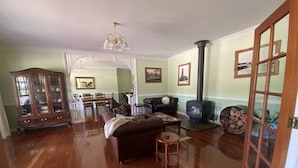 Un salón amplio con chimenea, muebles de madera y un comedor al fondo.