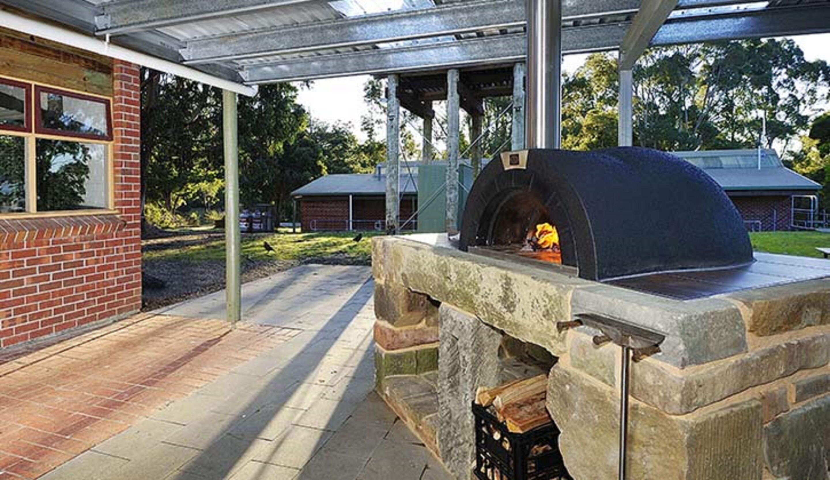 An outdoor brick building with a stone oven.