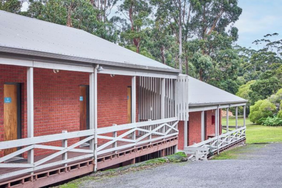 A brick building with a white roof and a covered porch.