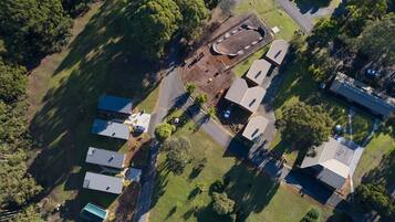 Vista aérea de una zona residencial con varias casas, una piscina y un amplio espacio abierto.