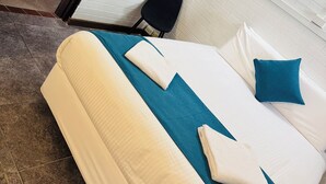 Habitación de hotel con una cama, una silla y vistas a una terraza de madera.