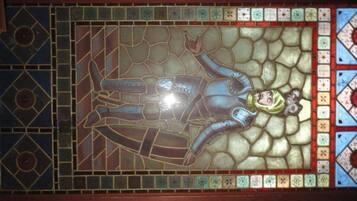 Una ventana de vitral con un diseño geométrico y una figura central.