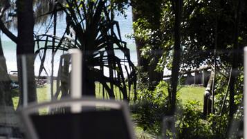 A view of a garden area with trees and a metal structure, likely a pergola, in the background.