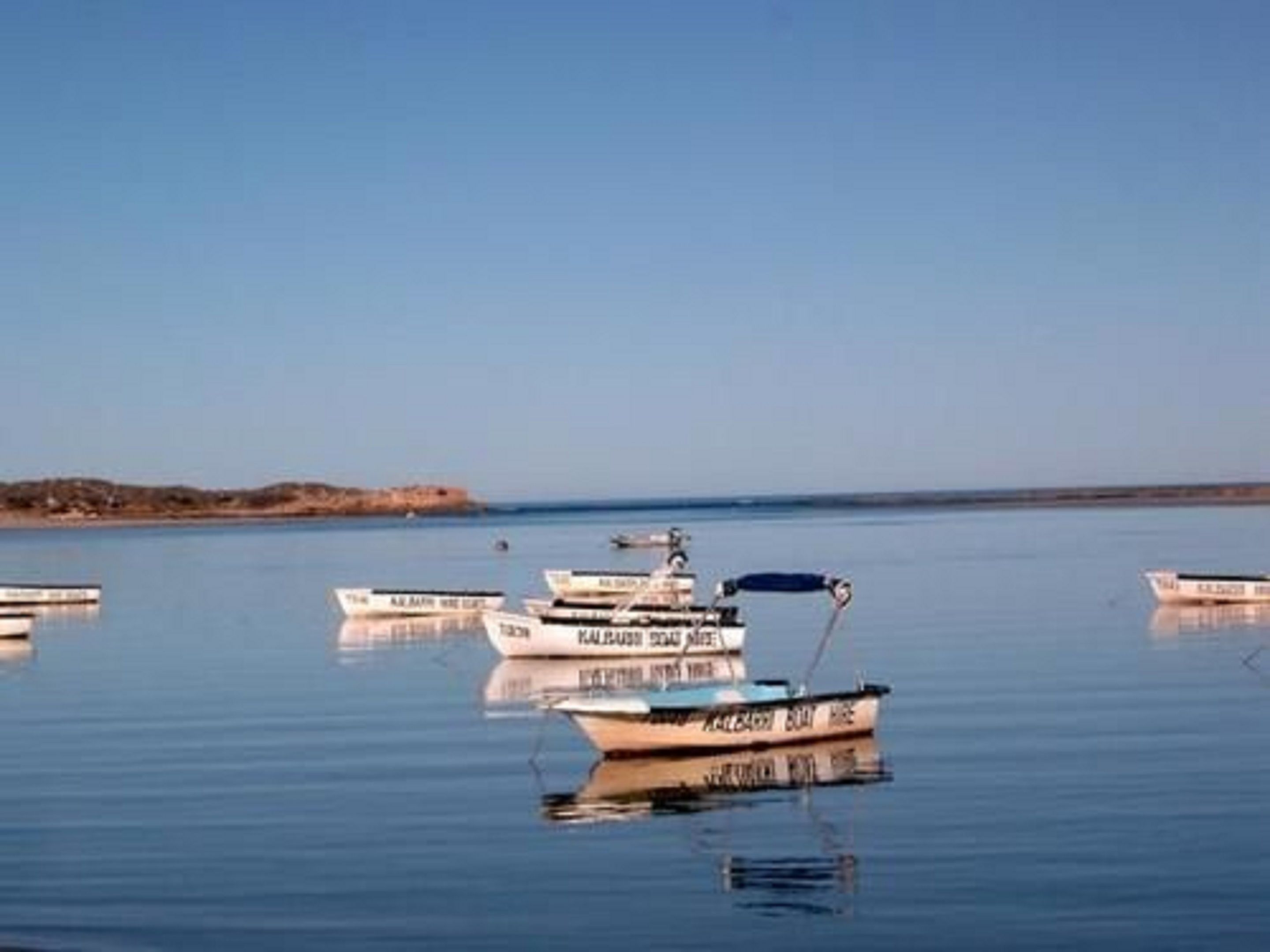 A calm body of water with several boats anchored.