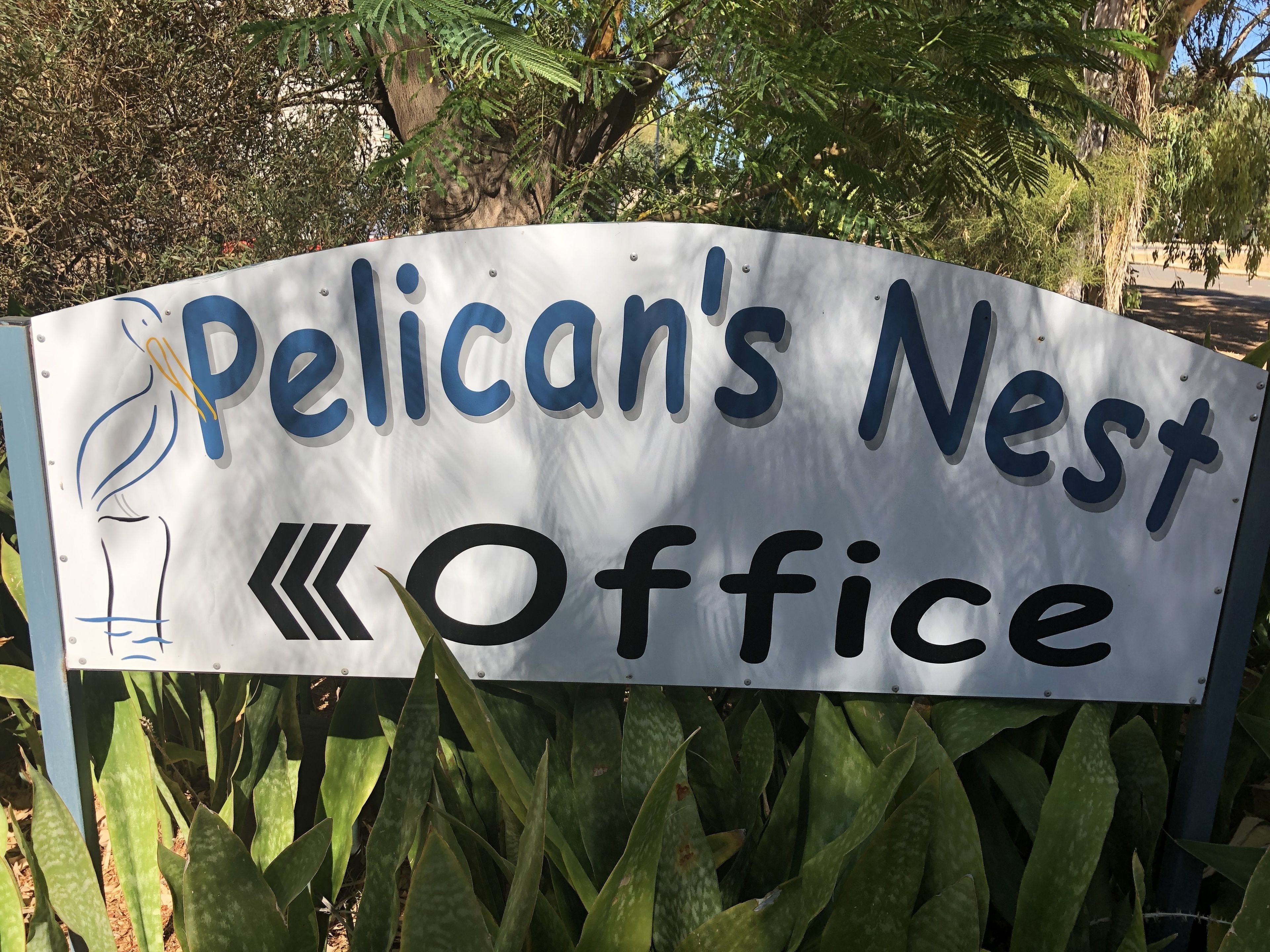 A sign for Pelican's Nest Office with a bird illustration.