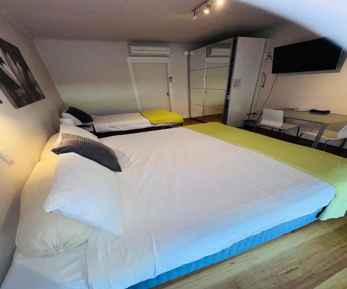 A bedroom with a large bed, a desk, and a chair.