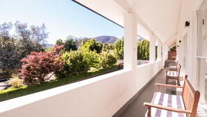 A balcony with a view of trees and hills. - Tower Motel (Marysville)