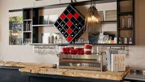 A bar area with a Brugnettis espresso machine, red and white mugs, and a sign that says "ROAD TRIP." - Tower Motel (Marysville)