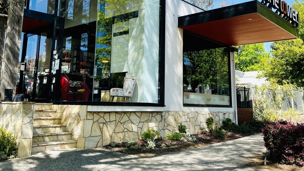 A modern building with large glass windows, a stone facade, and a sign reading "the tower." - Tower Motel (Marysville)