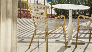 A balcony with wicker chairs and a round table, overlooking a pool and palm trees. - The Beachcomber Hotel & Resort (Toukley)