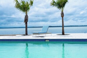 Una piscina al aire libre, sillones reclinables de piscina