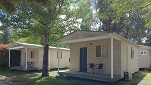 A row of mobile homes with a covered porch and two chairs. - Lithgow Tourist and Van Park (Bowenfels)