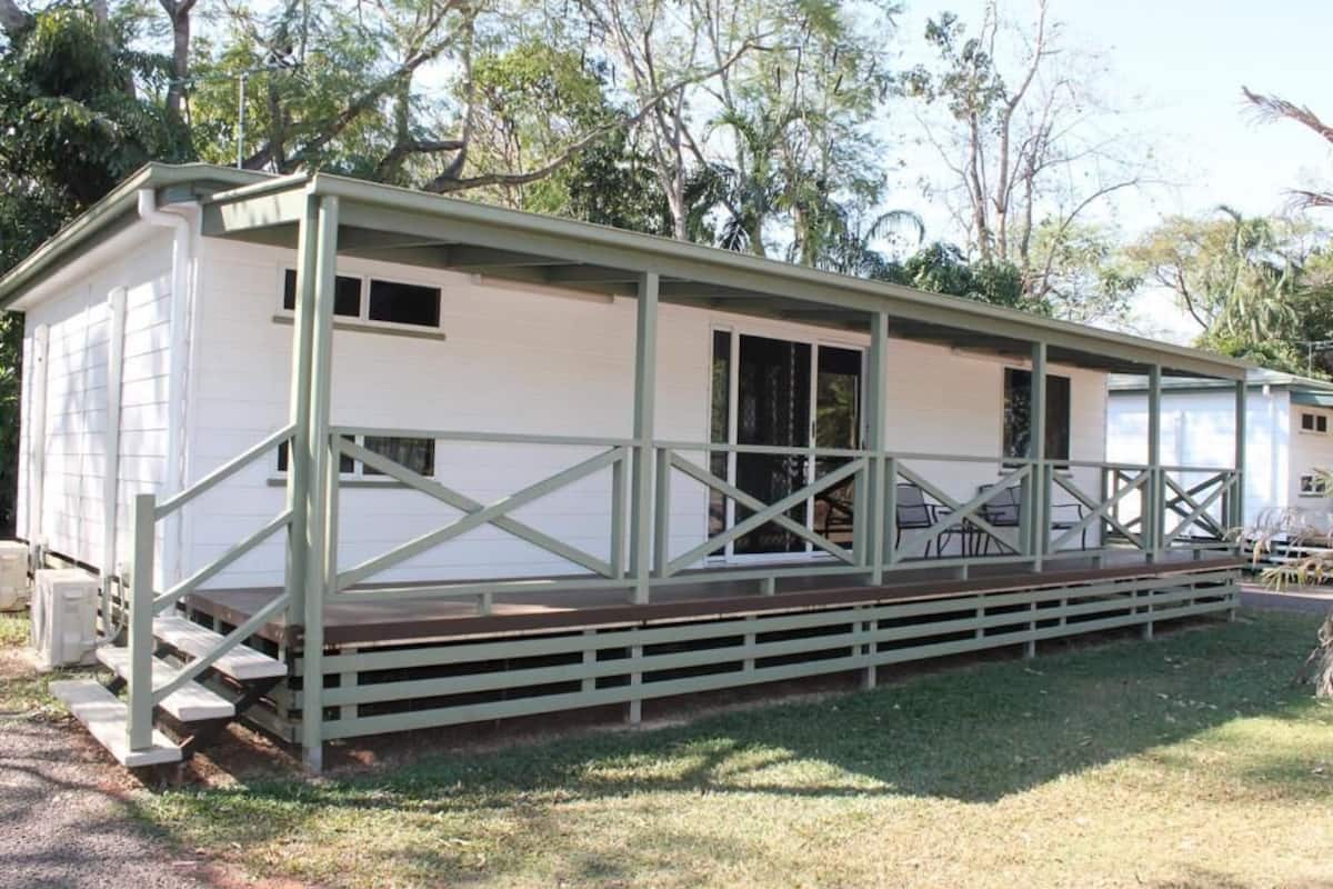Ein Bungalow mit Veranda und kleiner Terrasse.