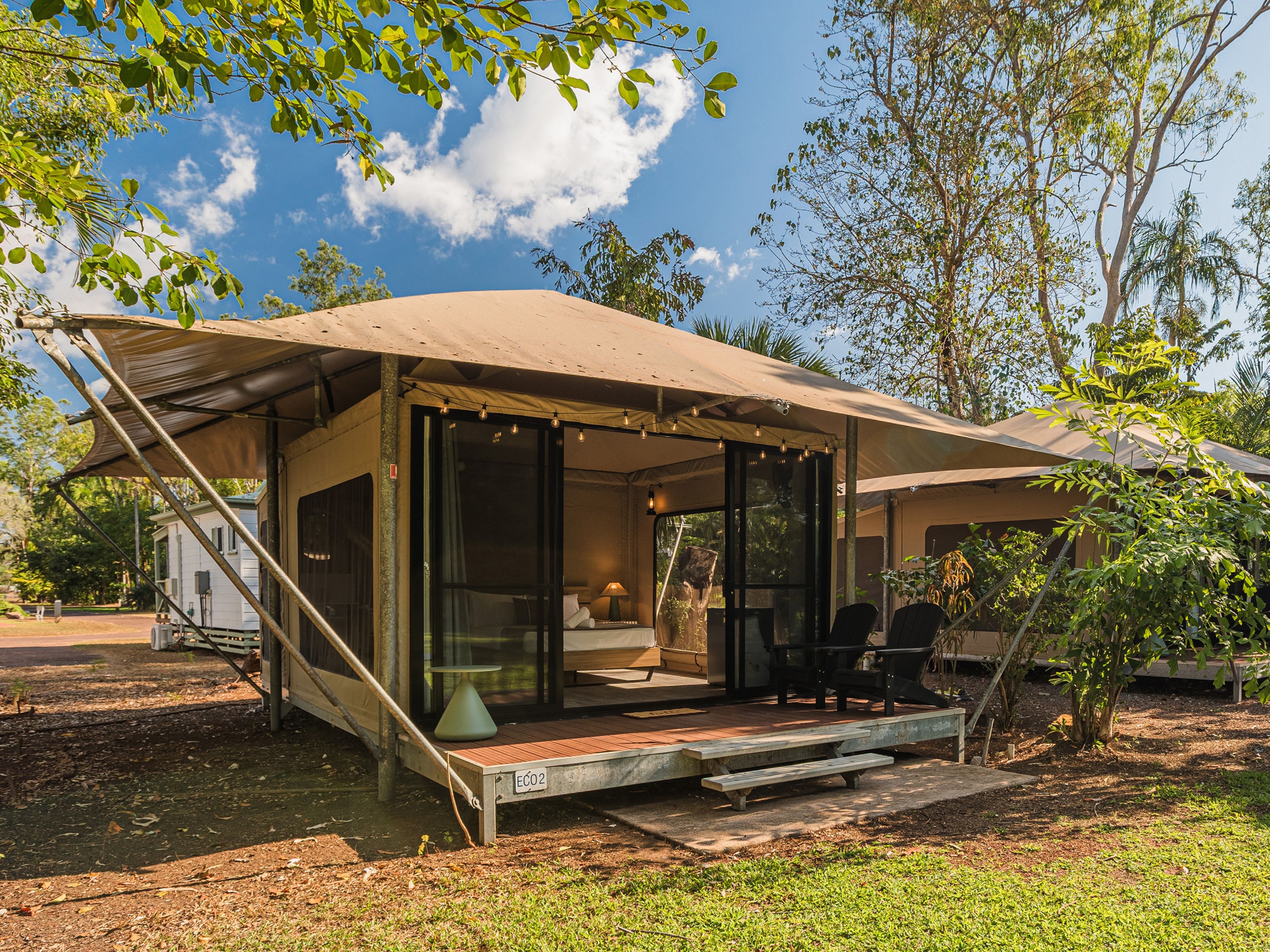A small, single-story structure with a covered patio area, a visible staircase, and a small outdoor seating area.