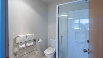 Un bagno moderno con cabina doccia in vetro, un water e un porta asciugamani.